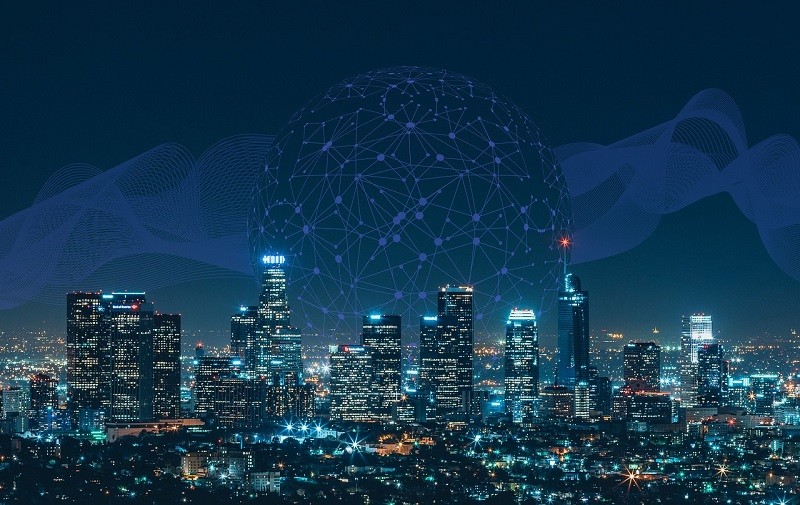 City skyline at night overlaid with a digital network graphic, representing connected technology and business innovation.