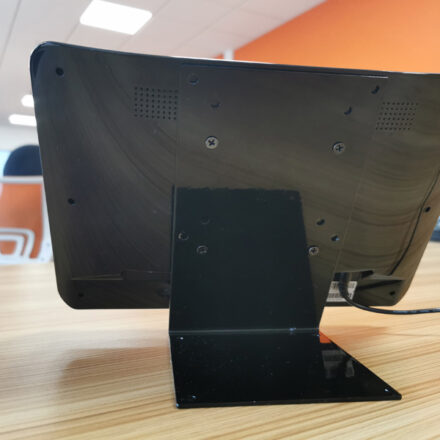 LCPOS02 POS table stand fitted to a small touch screen, shown from behind on an office desk, supporting VESA 100x100 mounting.