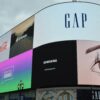 Large curved outdoor LED advertising screen in a busy city location, displaying multiple brand adverts.