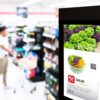 Freestanding digital signage totem displaying a salad promotion in a supermarket aisle, illustrating energy-efficient in-store advertising.