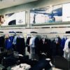 Retail clothing store interior with garment displays and branded lifestyle imagery.