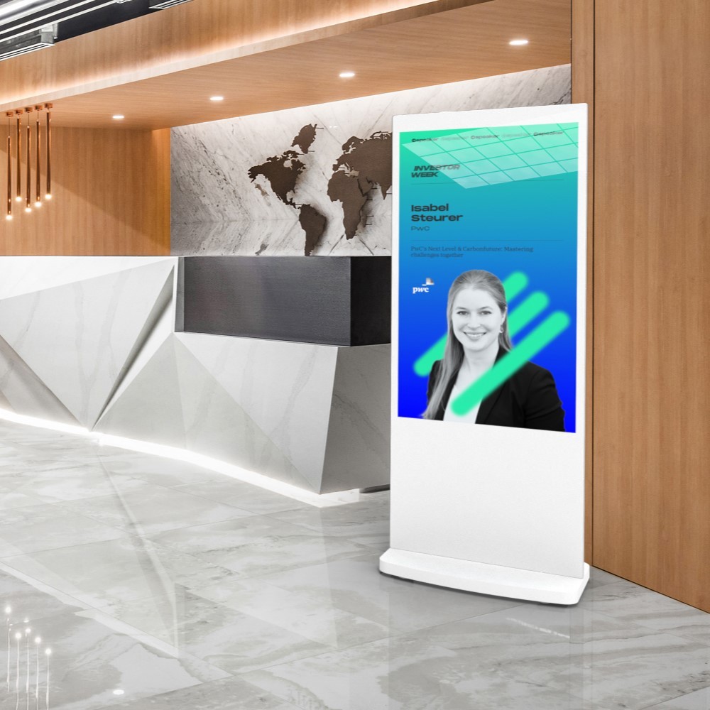 LCL50HDTW-NET – 50″ Touchscreen Freestanding Digital Poster, White, Network Enabled White 50-inch touchscreen freestanding digital poster in a corporate reception area, displaying event speaker information.