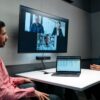 Bose Videobar mounted beneath a display in a meeting room, in use during a video conference call.