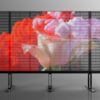 Fine pixel pitch transparent LED display on a freestanding frame, showing a vivid floral image.