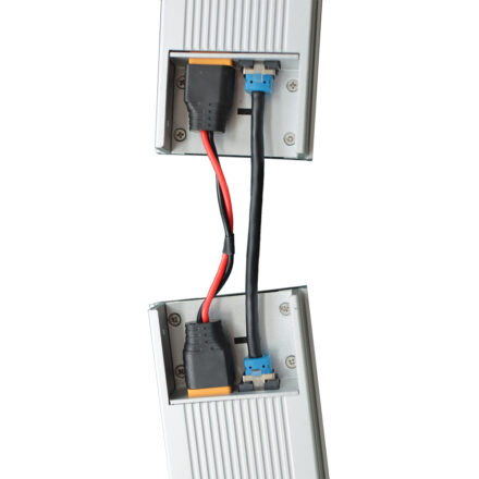 Two shelf-edge digital display units linked together via power and data jumper cable, demonstrating end-to-end connection between sections.