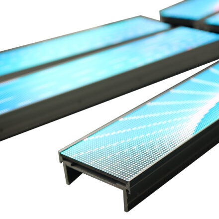 Multiple illuminated LED shelf-edge display strips arranged at angles, showing a bright graphic pattern rendered across the visible LED pixel grid.