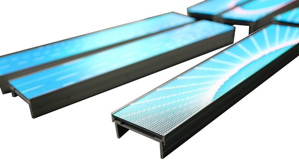 Shelf Display – Illuminated LED Strips in Operation Multiple illuminated LED shelf-edge display strips arranged at angles, showing a bright graphic pattern rendered across the visible LED pixel grid.