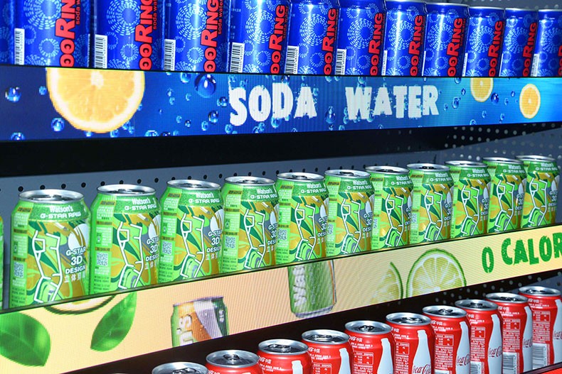 MiniCOB LED Display – Shelf Edge Close-Up Close-up of MiniCOB LED shelf-edge strips displaying soda water branding above rows of canned beverages.